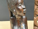 two wooden sculptures of a woman and a man on a table