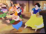 Blanche-Neige et les Sept Nains de Disney dansent dans une pièce