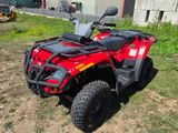 an image of a red four wheeler atv parked in a field