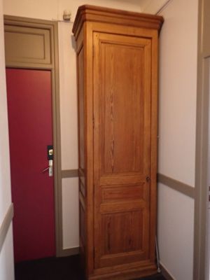 un grand meuble en bois dans le coin d'une pièce