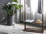 une plante posée sur un support à côté d'un miroir
