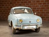 a small blue car parked in front of a brick wall
