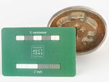 a green credit card sitting next to a coin