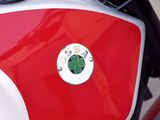 a close up of a red and white motorcycle with a black handlebar
