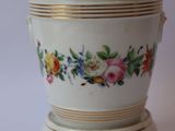 a close up of a vase with a bunch of flowers on it
