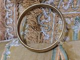 a gold ring sitting on top of a pillow on a bed