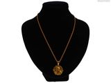 un collier avec une pièce d'or autour du cou d'un mannequin