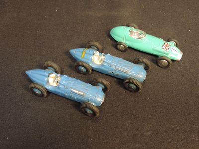 three toy cars that are sitting on a black surface