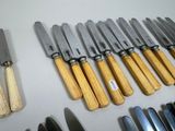 a lot of knives that are lined up on a table