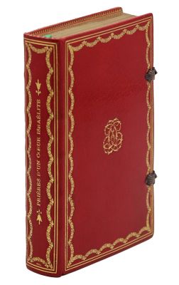 un vieux livre rouge orné de dorures et d'une bordure dorée