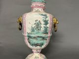 a vase with a lid that has a picture of a man in a boat on it