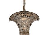 un vase en argent richement décoré, orné d'un oiseau sur fond blanc