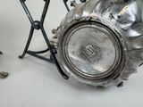 a silver vase sitting on top of a table next to a pair of scissors