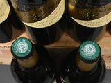 several bottles of wine sit on a shelf in a store