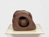 sculptures made of wood sit on top of a white pedestal