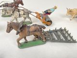 several figurines of horses pulling a cart with a man on it