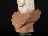 marble bust of a young man with long hair on a pedestal