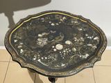 a black table with shells on it on a tiled floor