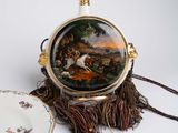 a purse with a picture on it next to a plate