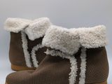 a close up of a pair of brown shoes with white fur on them