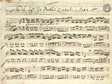 an old manuscript with music notes on it and a pen in the middle
