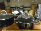 de nombreuses casseroles et poêles posées sur le plan de travail de la cuisine
