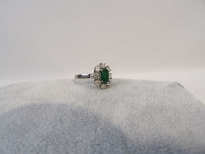 un gros plan d'une bague ornée d'une pierre verte sur un fond blanc