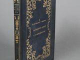 un livre bleu aux bords dorés posé sur une table