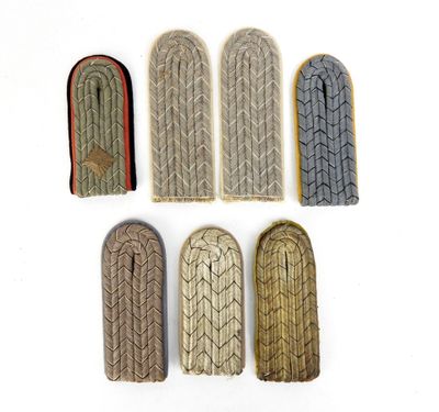 six paires de vieilles chaussures tricotées sont alignées sur une surface blanche