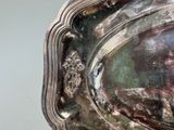 a silver plate with a picture of a woman on it