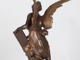 an image of a bronze statue of an angel holding a book