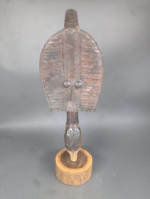 une image d'une sculpture en bois représentant un oiseau sur un support