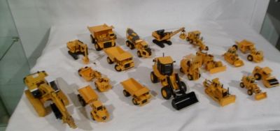 tout un tas de petits engins de chantier en plastique posés sur une table
