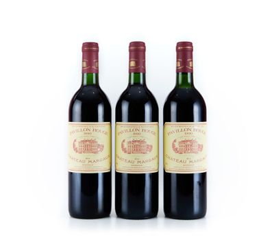 trois bouteilles de vin rouge posées l'une à côté de l'autre sur une surface blanche