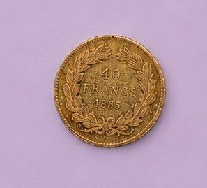 une pièce d'or posée sur une surface blanche, sur fond violet
