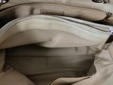 the inside of a beige purse with a zipper on it