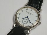 a close up of a wrist watch on a white surface