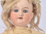 a close up of a doll with blonde hair and blue eyes