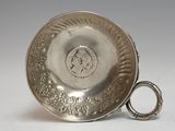 a silver plate with a ring on it on a table