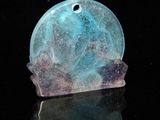 a picture of a blue and purple glass object on a black surface