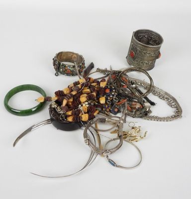 un tas de bijoux posés sur une surface blanche, avec des ciseaux