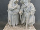 deux figurines représentant deux hommes portant un chapeau et une canne