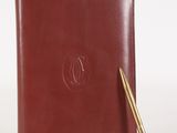 un carnet en cuir marron sur lequel est posé un stylo