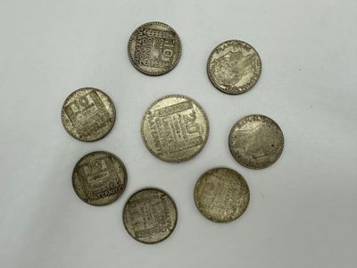 un groupe de cinq pièces d'argent posées sur une surface blanche