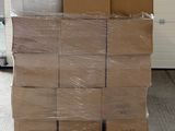 une grande pile de cartons posée sur une palette devant la porte d'un garage