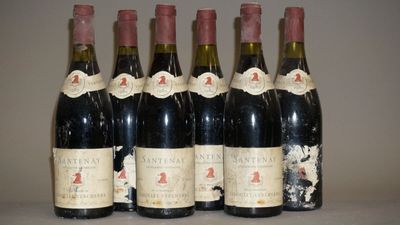 six bouteilles de vin sont alignées sur une table