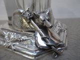 une assiette en argent sur laquelle sont représentés un chat, un couteau et une fourchette