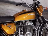 a yellow motorcycle parked in a garage with a white wall
