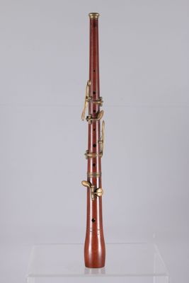 a close up of a wooden bassoon on a clear acrylic stand