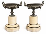 pair of antique bronze vases on marble pedestals on white background